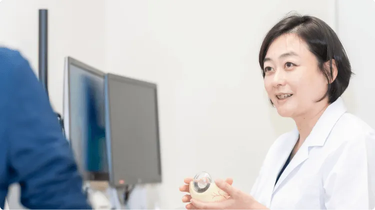 患者に眼内レンズを見せながら説明を行う医師
