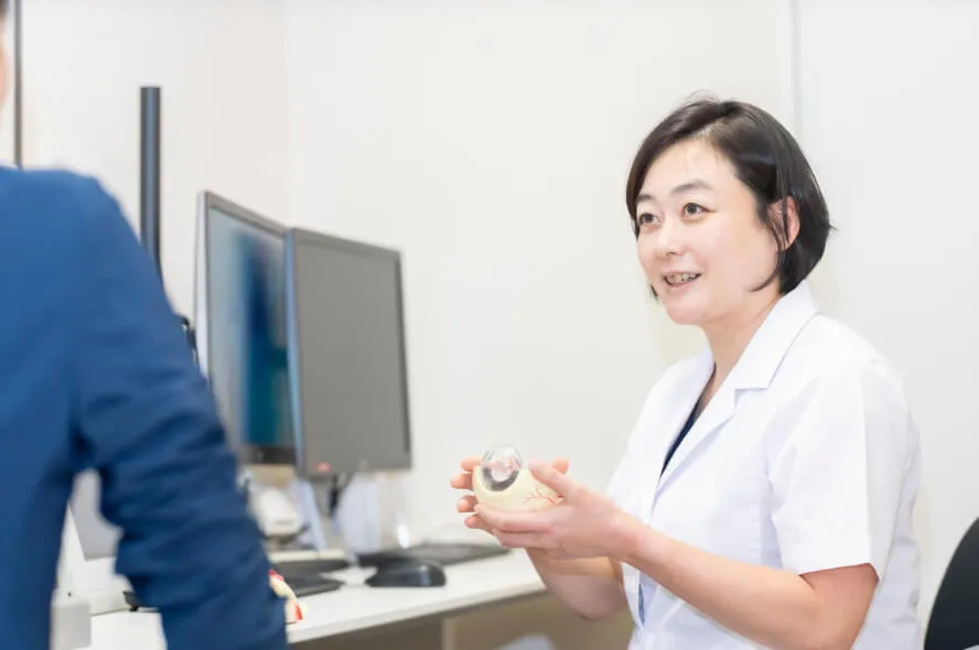 患者に眼内レンズを見せながら説明を行う医師